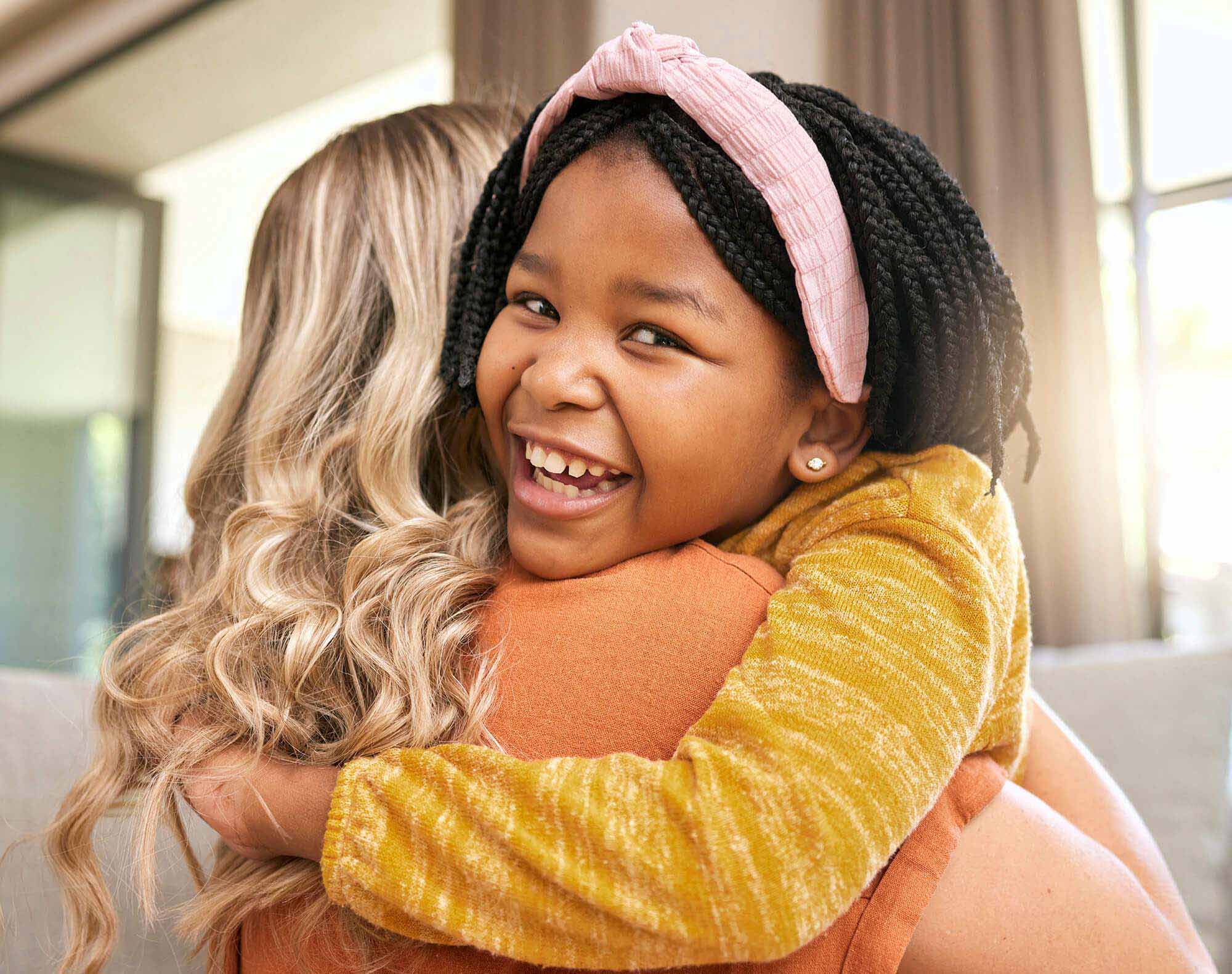 hug-mother-and-adopted-black-girl-in-living-room-2023-11-27-05-23-56-utc.jpg